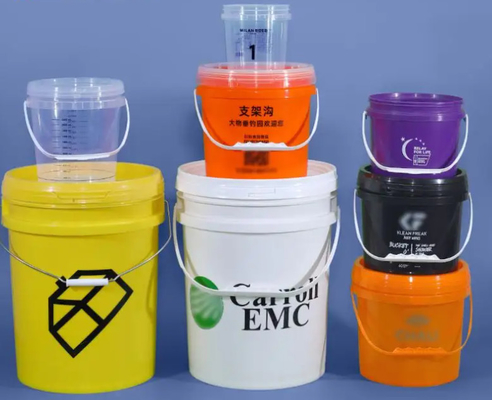 Des seaux en plastique blancs empilés pour les besoins des clients